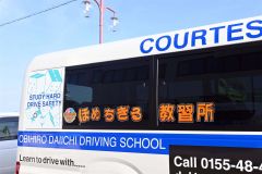 「ほめちぎる教習所」と記載された送迎バス