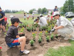 更農の生徒と花植に取り組む児童たち