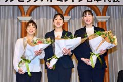 北海道バドミントン協会から花束を受け取り、笑顔で写真に収まる（左から）東野有紗、永原和可那、松本麻佑の３選手（金野和彦撮影）