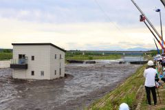 破堤した堤防からあふれ、住宅に押し寄せる大量の水（２７日午後４時ごろ、助川かおる通信員撮影）