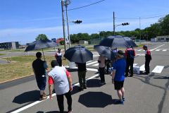 暑さ対策として、参加者は日傘を差しながら指導員の話を聞いた（３０日午前１０時３５分ごろ、おびひろ自動車学校）