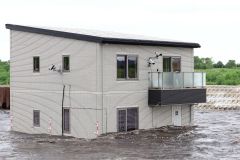 木造住宅に水が押し寄せる様子（助川かおる撮影、６月２７日午後４時ごろ）
