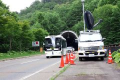 糠平トンネルを出た自動運転バス。右は移動衛星車両（助川かおる通信員撮影）