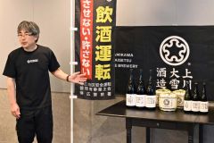 啓発ラベルが付いた日本酒瓶について説明する上川大雪酒造の若山健一郎取締役（１０日午後４時２０分ごろ、上川大雪酒造碧雲蔵Ｓｈｏｐ）
