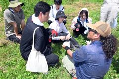 大麦畑の草取りを終え、鈴木ＣＥＯ（左）の話に耳を傾ける学生