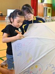 傘いっぱいに絵を描く帯広聾学校の児童（左）と見守る幕別清陵高校の生徒