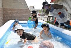 ２歳児クラスでは日よけの下にプールを設置。自然と笑顔がこぼれる子どもたち（松葉保育所）