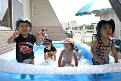 ２歳児クラスでは日よけの下にプールを設置。自然と笑顔がこぼれる子どもたち。
