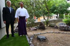 音更神社の社務所中庭にお目見えした十勝石庭園を紹介する（右から）佐々木宮司と波多野さん