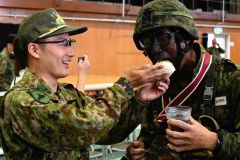 訓練を乗り越え、飲み物片手にケーキにかぶり付くレンジャー学生