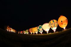 熱気球が夕闇に浮かび上がったバルーングロー（助川かおる通信員撮影）