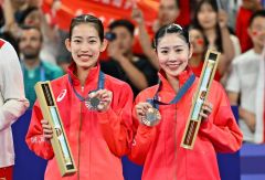 女子ダブルスで銅メダルを獲得し表彰台で笑顔を見せる志田千陽（右）と松山奈未（３日、金野和彦撮影）
