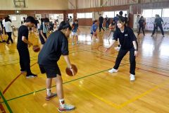 選手（右）から手話を交えてバスケを教わる子どもたち