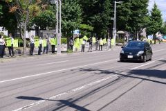 安全運転を呼び掛ける旗を掲げる関係者