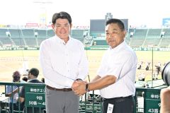 甲子園で握手し、健闘を誓い合う白樺学園の亀田直紀監督（左）と創成館の稙田龍生監督（６日午前８時半ごろ）