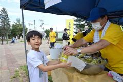 レモネードを笑顔で受け取る小学生