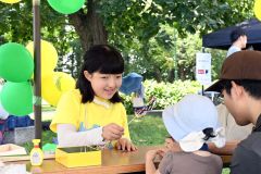 訪れた子どもに風車の作り方を教える飯田さん