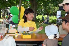 訪れた親子連れに風車の作り方を教える飯田さん