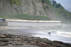 黄金道路沿いのフンベ海岸はサーフィンの道内有数のスポット。サーファーたちは覆道を眺めながら、波乗りを楽しむ