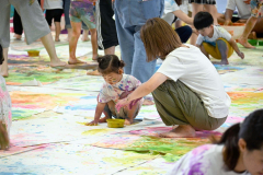 手で紙に色を塗る子どもら