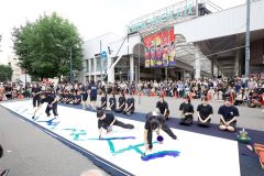 「日高山脈襟裳十勝国立公園」誕生を祝って行われた開幕パフォーマンスで、山並みを力強く書き進める生徒ら（平栗玲香通信員撮影）