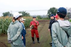 坂東農場で岡野さんの話を聞く学生ら