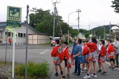 久野さん（左から３人目）から海岸エリアの防災について説明を受ける児童