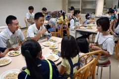 皆で手作りのうどんや天ぷらを味わう参加者ら