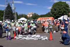 倒壊した住宅内に水が流れ込むのを土のうを摘んで防ぐ参加者ら