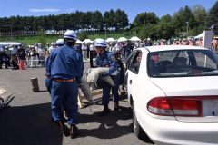 倒壊した工事現場で鋼材の下敷きになった車両の中から負傷者に見立てたダミー人形を救出する消防団員ら