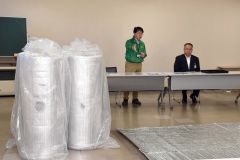 避難所で床冷えを防ぐシートを寄贈した赤坂社長（左）＝池田町役場提供