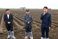 じゃがいも畑の前であいさつをする（左から）田崎一也社長、橋詰仁組合長、杉浦大斗幕別支所長（５日、午前１０時ごろ、帯広市以平町で。金野和彦撮影）