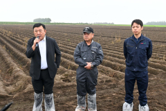 じゃがいも畑の前であいさつをする（左から）田崎一也社長、橋詰仁組合長、杉浦大斗幕別支所長（５日、午前１０時ごろ、帯広市以平町で。金野和彦撮影）