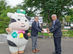 稲葉園長（右）に目録を渡す蔵田部長