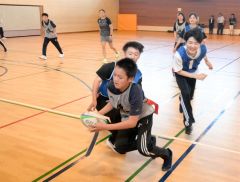 桑井さんに審判を務めてもらい、タグラグビーを楽しむ生徒ら