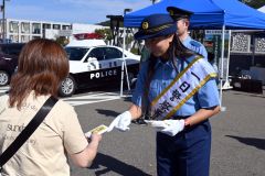 啓発グッズを手渡し、詐欺への注意を呼び掛ける桑井さん