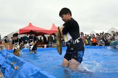 秋サケのつかみ取りに奮闘する子ども（２１日午前１１時１５分ごろ、須貝拓也撮影）