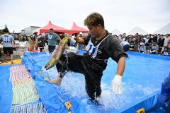 秋サケのつかみ取りで奮闘する参加者（２１日午前１１時ごろ、須貝拓也撮影）