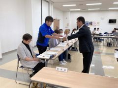 佐々木町長（右）から任命書を受け取る岡崎新会長