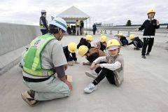 整備中の歴舟川橋の路面部分に落書きをする大樹小の児童