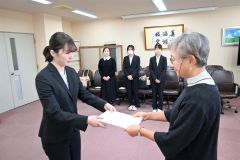 吉田副学長（右）から奨学生証を受ける山下さん（左）