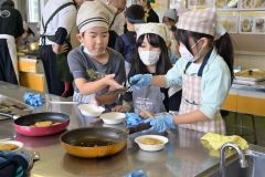 焼き立てのいももちを盛り付ける子どもたち