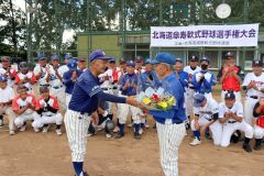 引退する９４歳の紺野郷視選手（手前右）に花束を贈る林芳章実行委員長（同左）