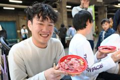 限定５００食の「生本マグロ丼」を手にする買い物客（２９日午前９時５０分ごろ、須貝拓也撮影）