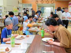 青年部員と食事を楽しむ児童ら