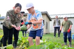 円山動物園のアジアゾウ飼育員の鎌田さん（左）とカボチャを収穫した児童