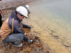 青沼の水質を調査する専門家。青く見える水の色は、沼の底の白色の泥も影響している可能性がある