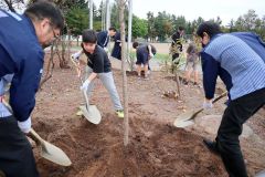 植樹する児童とローソン関係者