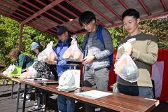 野菜重量当てクイズで奮闘する出場者（１３日午前１０時半ごろ、須貝拓也撮影）