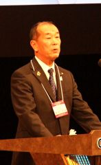 歓迎の言葉を述べる飯田会長